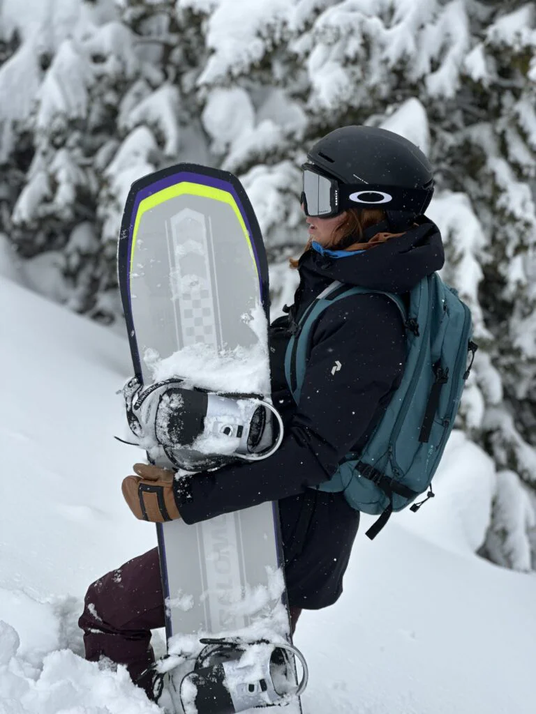 Snowboarder con manoplas Rockerol en un bosque nevado