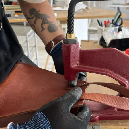Col·locació d’un rebló en una peça de pell al taller Rockerol